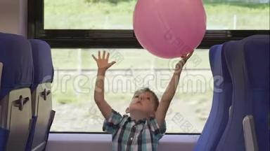 可爱的小男孩在<strong>火车</strong>上玩粉红色的气球，而它在移动。 <strong>儿童</strong>度假和旅游